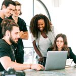 Dynamic team of young adults collaborating on project in bright modern office environment.